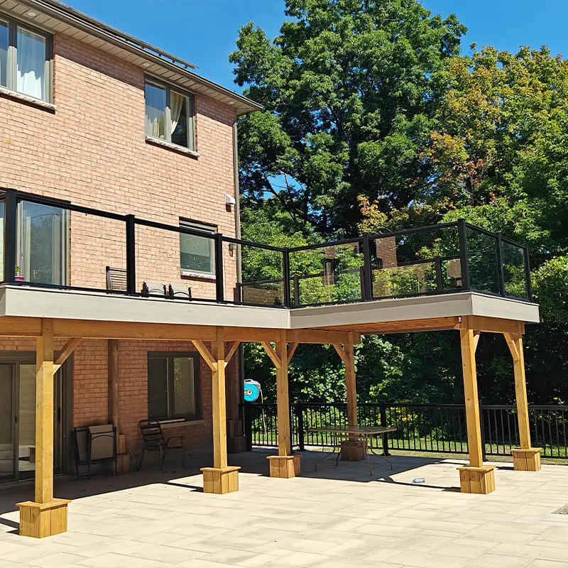 Elevated backyard deck with black aluminum and glass railing installed by Megapol Deck in GTA.