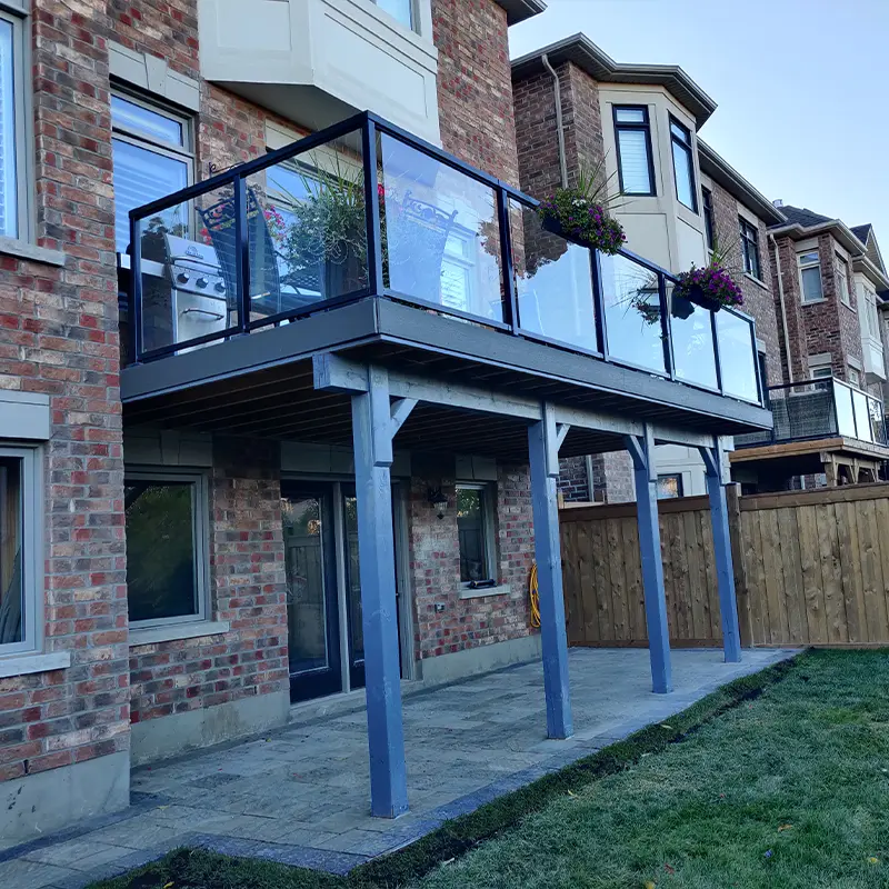 Second-story deck with glass railing system installed by Megapol Deck in GTA backyard.
